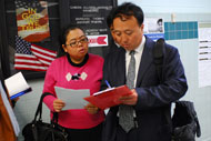 Christine Yuan and Cong Riyun complete the observer checklist as polls open in Falls Church, Va.