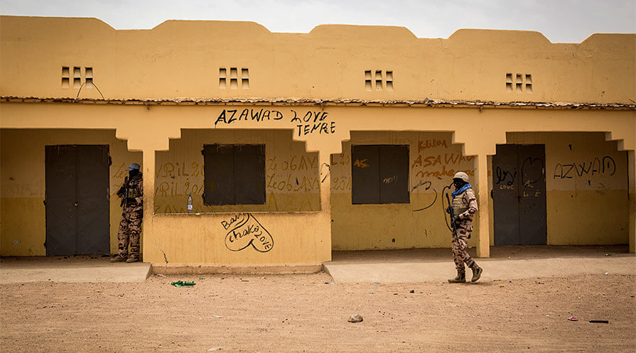 Chadian U.N. peacekeepers patrol Ecole Bam, a school with about 800 students, while Carter Center representatives speak with school directors inside. Since the rebellion in 2012, schools have operated with skeleton staffs made up mostly of volunteers. Parents who can afford better send their children south to stay with relatives and attend school there.