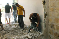 Friends help the Sa'id family demolish the second floor of their home.