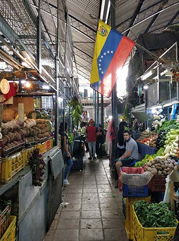 Vegetable line an aisle at the Caracas market.