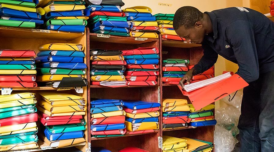 MORDOR data manager Diallo Beidi sorts through folders documenting the deaths of hundreds of small children in Niger, which has a tragically high child mortality rate.  