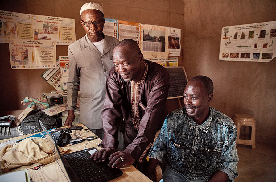  From left: Souleymene Tahirou Aboubacar, health communications advisor; Amadou Roufai Ousmane, director of community radio station Radio Albichir: and Barmou Moudi, Carter Center sanitation technician, discuss health programming at the station.