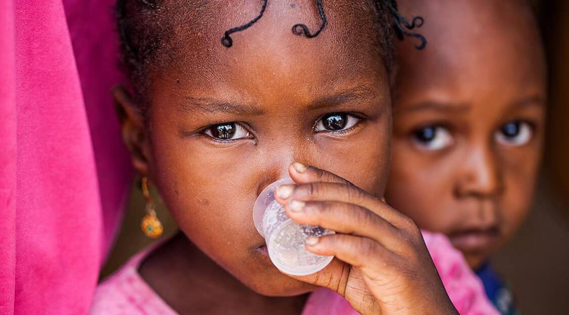 A girl in Bossadje, Niger, drinks from a dosing cup as part of an international study that has shown a link between azithromycin and reductions in child mortality.