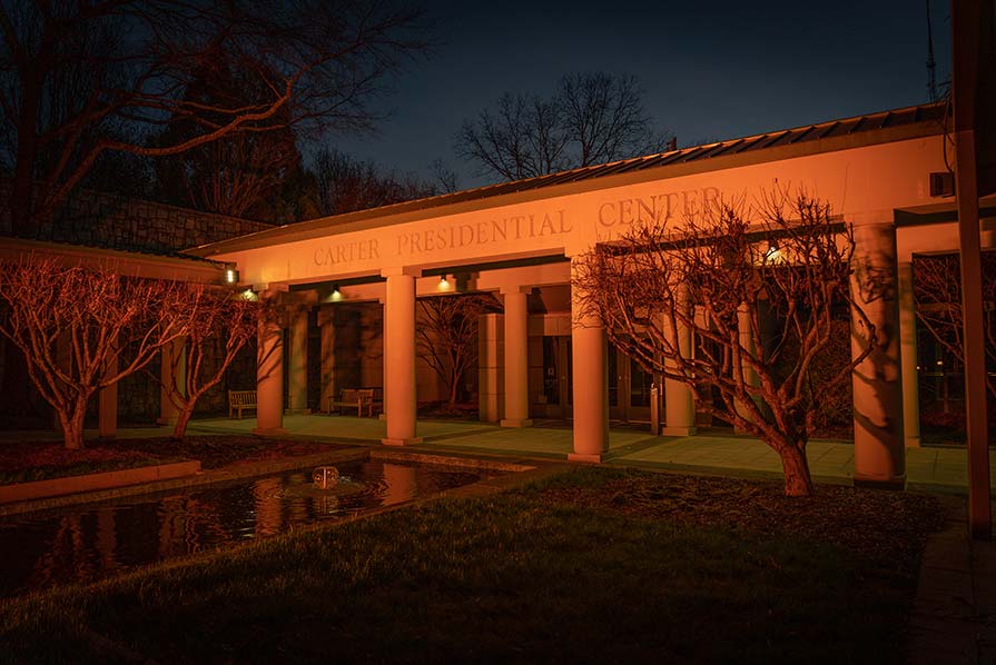 Photo of Jimmy Carter Presidential museum front exterior illuminated with orange light.