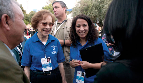 Former First Lady Rosalynn Carter talks with people waiting to vote in Sidi Bou Said, Tunisia, along with her translator Nedia Haddad.