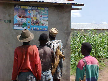 Ghanaian men study a poster at a school.