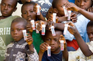 Children with schistosomiasis hold samples of their urine.