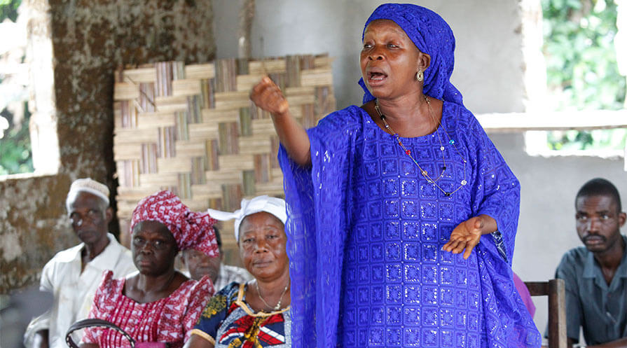 A woman addresses her fellow participants during a meeting at Forzohn Town, Mambahn  District, Margibi County, Liberia. Through a nationwide effort to empower them, more women possess the courage to give their views in public meetings and participate in local government.