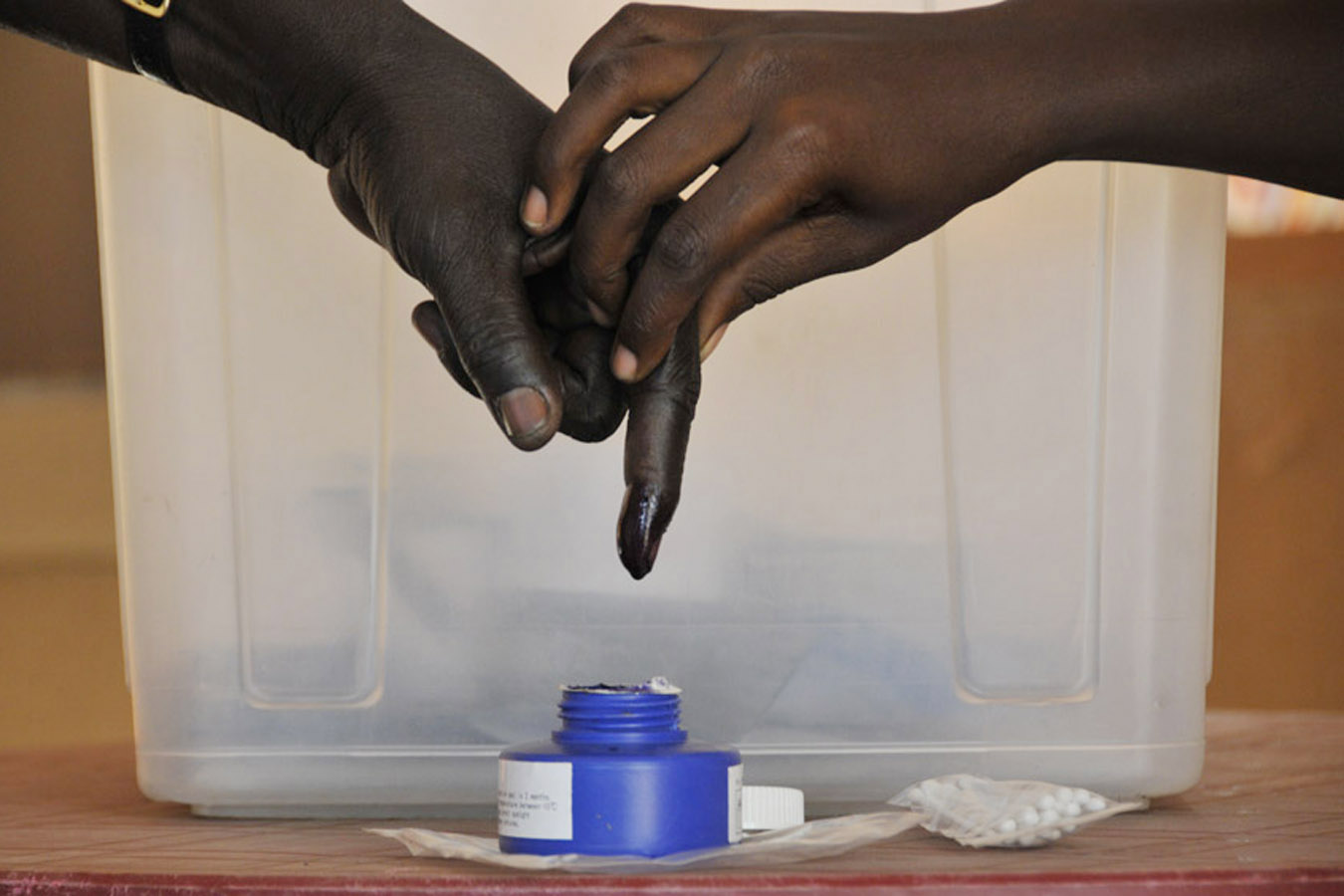 A man has his finger dipped in indelible ink after voting on Jan. 9.