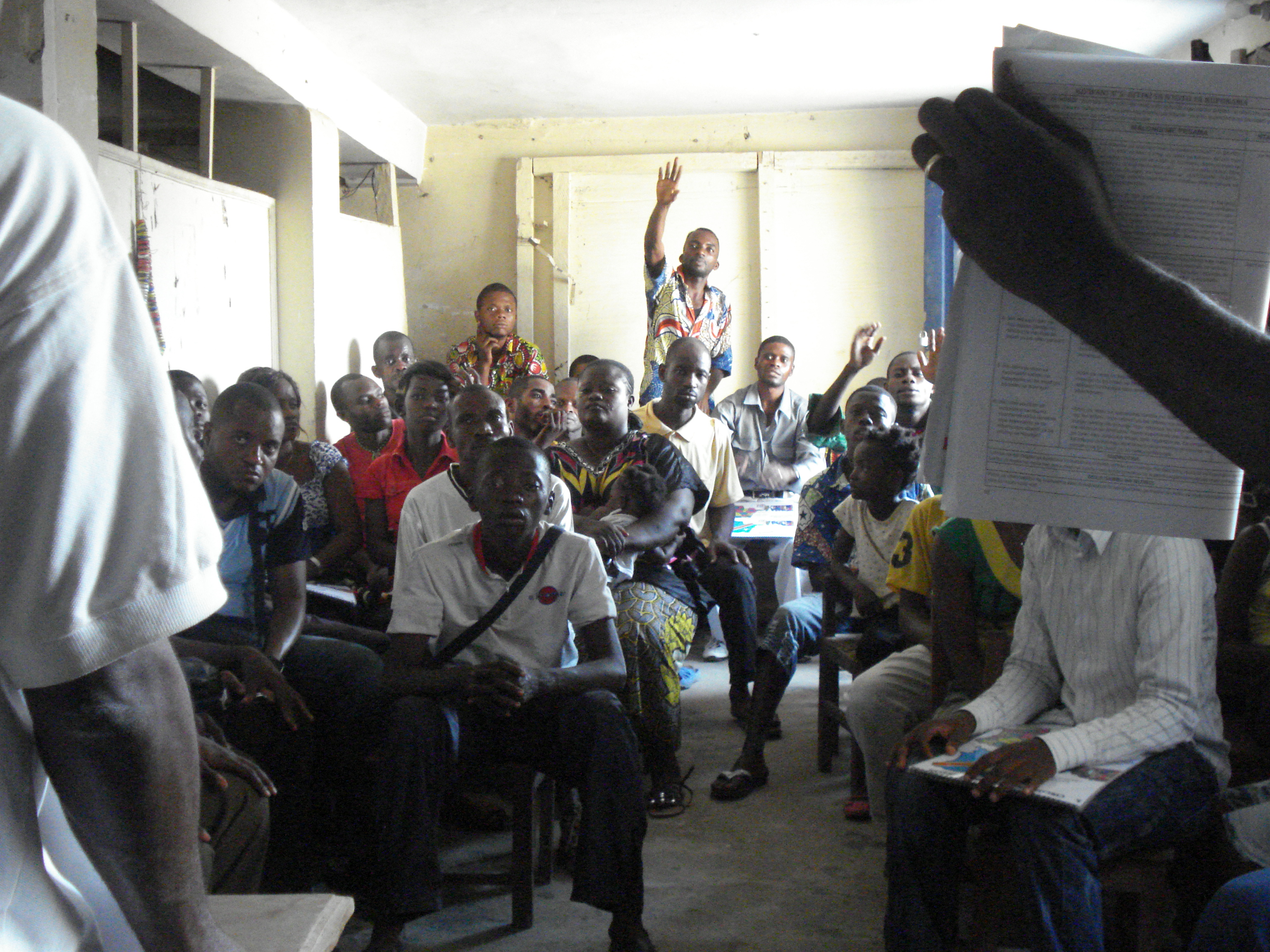 Deaf voter raises his hand to ask question during workshop in DRC.