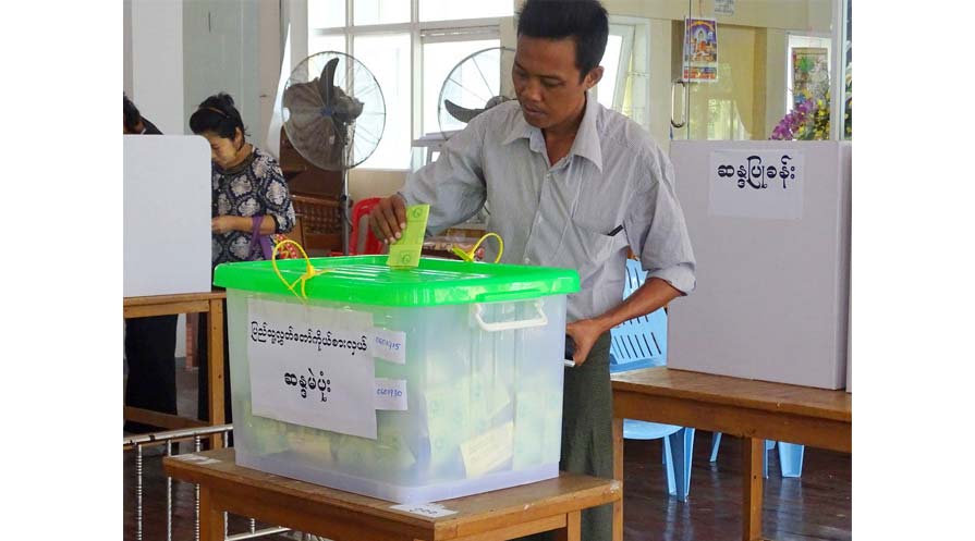 Photo of a voter casting his ballot at a polling station inside a Buddhist community center in Yangon. 