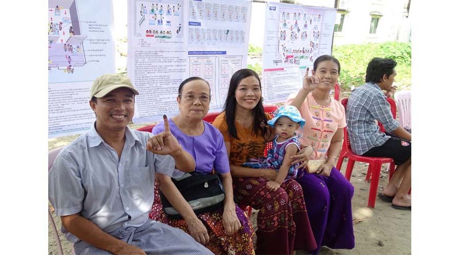 Photo of a family after voting - two members hold up an ink-blotted finger.