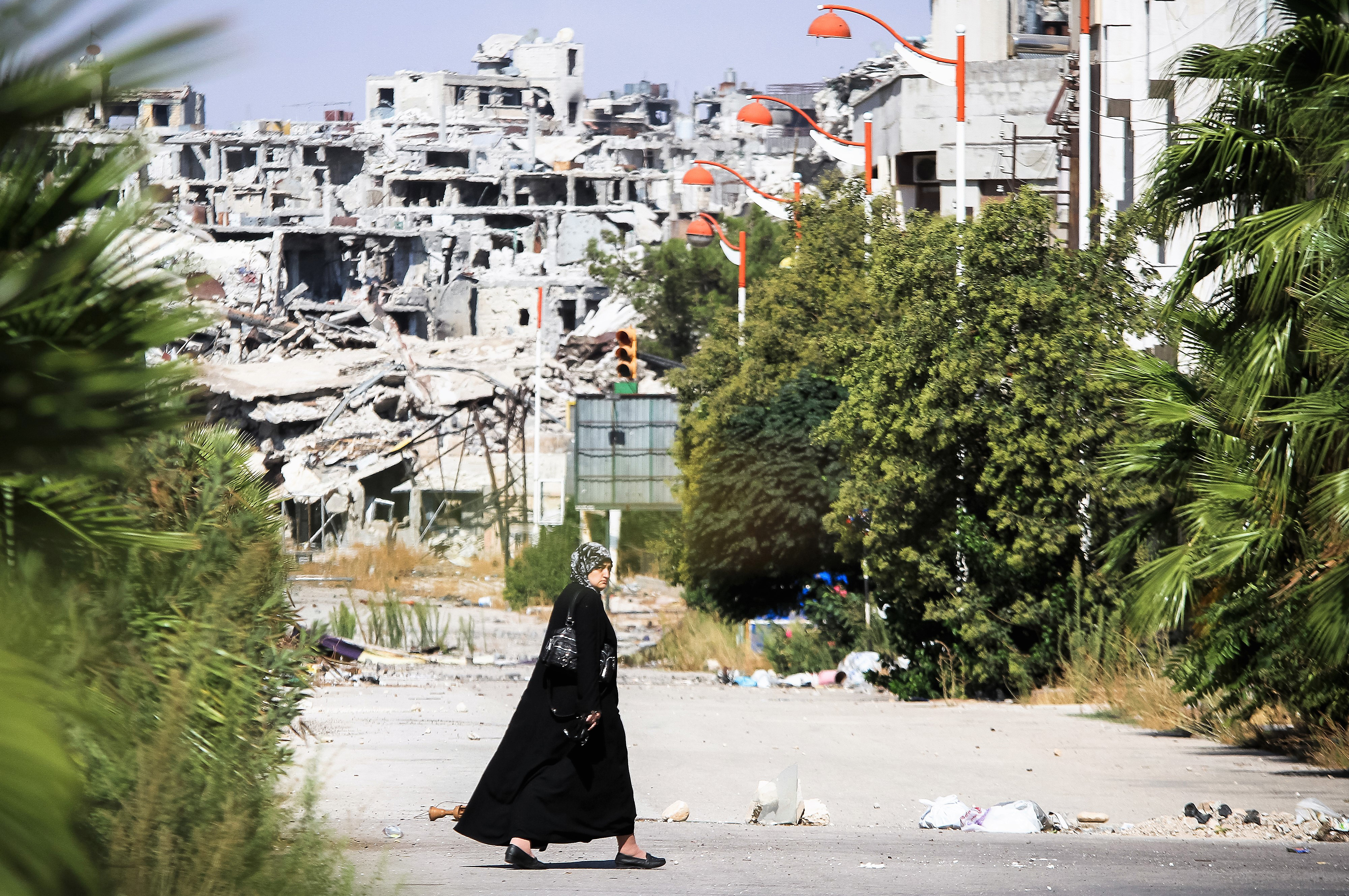 A woman walks in 2013 near a residential area in the Syrian city of Homs, destroyed in fighting between the rebels of the Syrian National Army. (Photo: iStock.com)