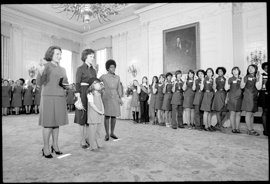 Black and white photo of Rosalynn Carter with uniformed members of the Girl Scouts of America.