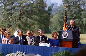 Jimmy Carter delivers an address at the podium of an outdoor ceremony.