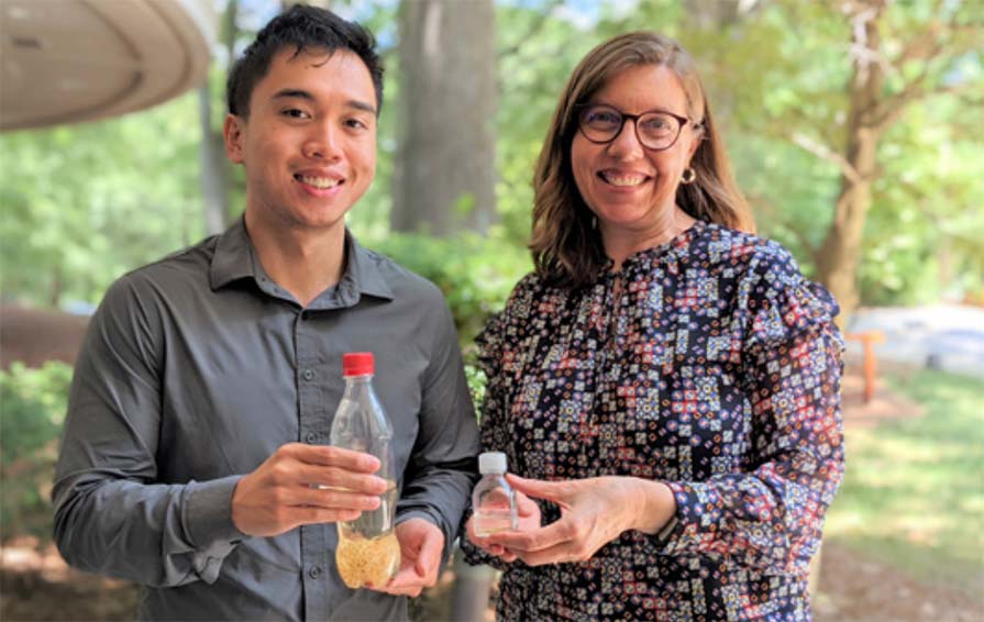 Phong Le and Madelle Hatch hold bottles of preserved Guinea worms.
