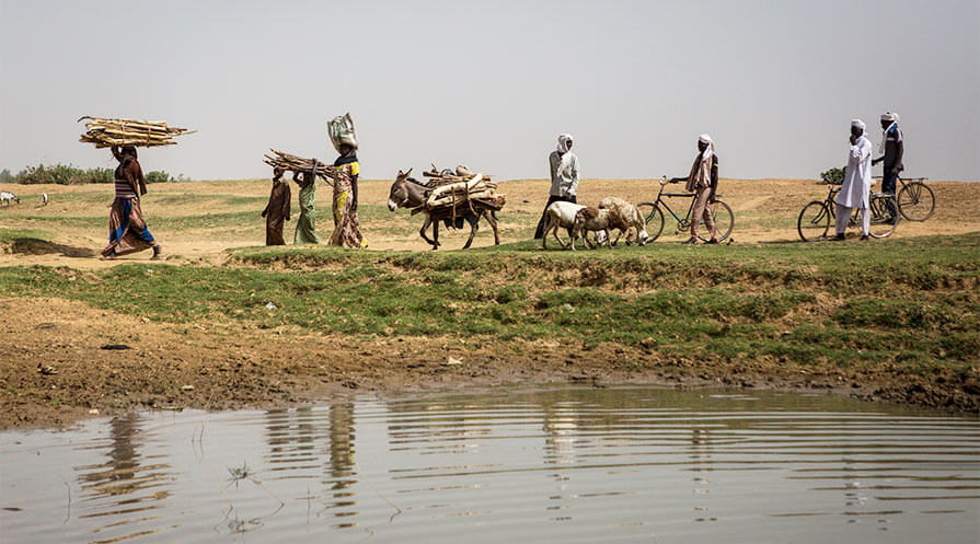 Residents of Geulengdeng, Chad, pass by a pond while carrying out daily tasks. Chad reported 17 cases of Guinea worm disease in 2018.