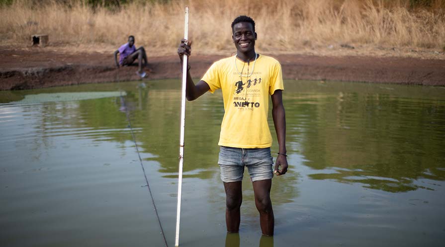 Photo of Wegwa Odol Othow standing in mid-calve deep pond water.