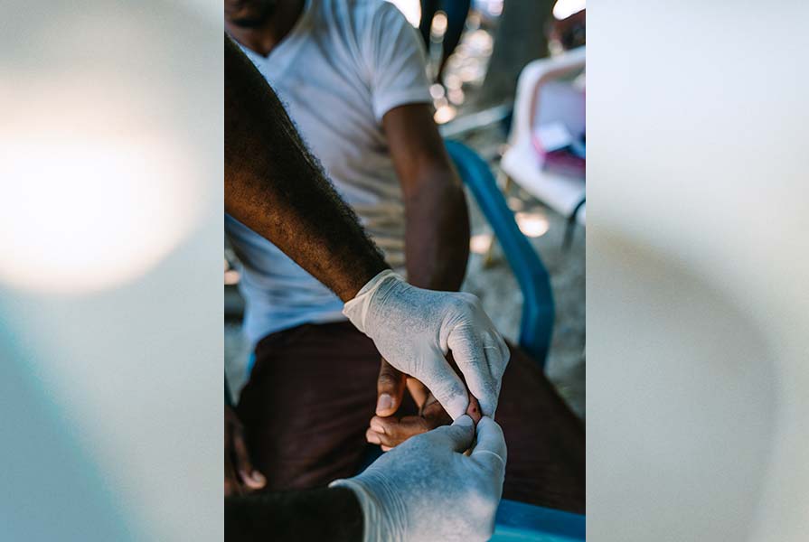 A blood sample is taken from a finger.