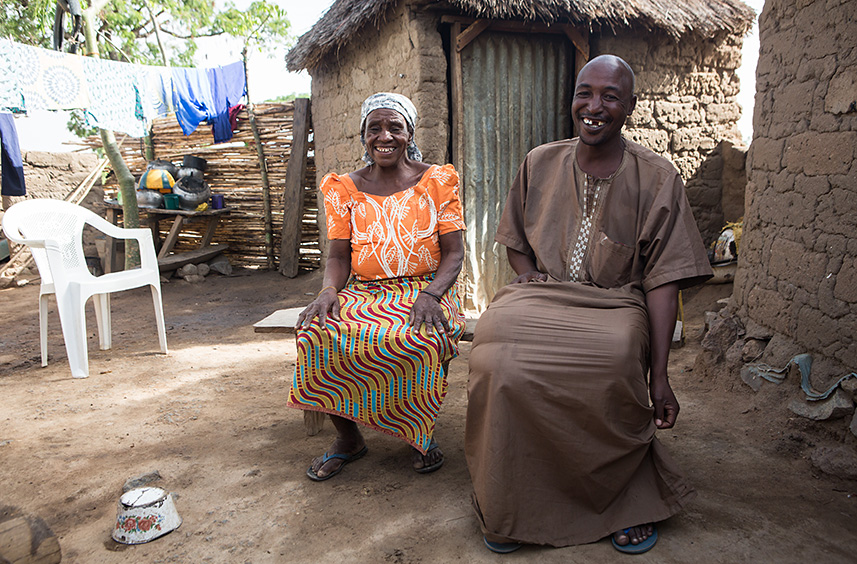 Sama’ila Simon (right) lives with an extremely enlarged right leg due to the parasitic disease lymphatic filariasis. He lives with his brother’s family and has never married, common for those with the disease due to the severe social stigma that accompanies it. 