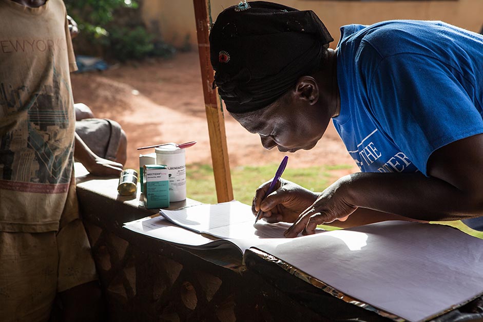 After providing the medication, Orji makes notes about who was treated and when, so no community members are missed.