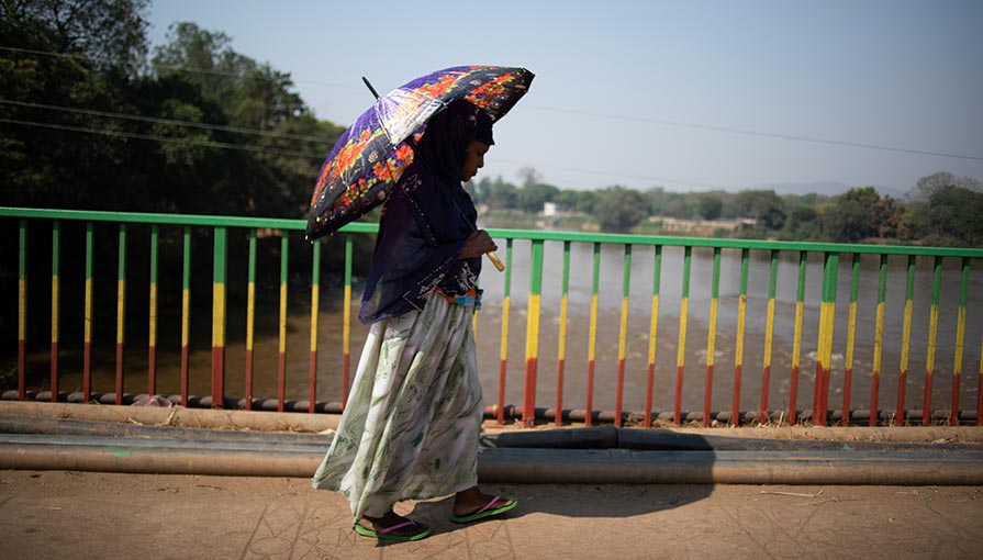 A woman crosses a bridge over the Baro River in Gambella Town, Ethiopia.