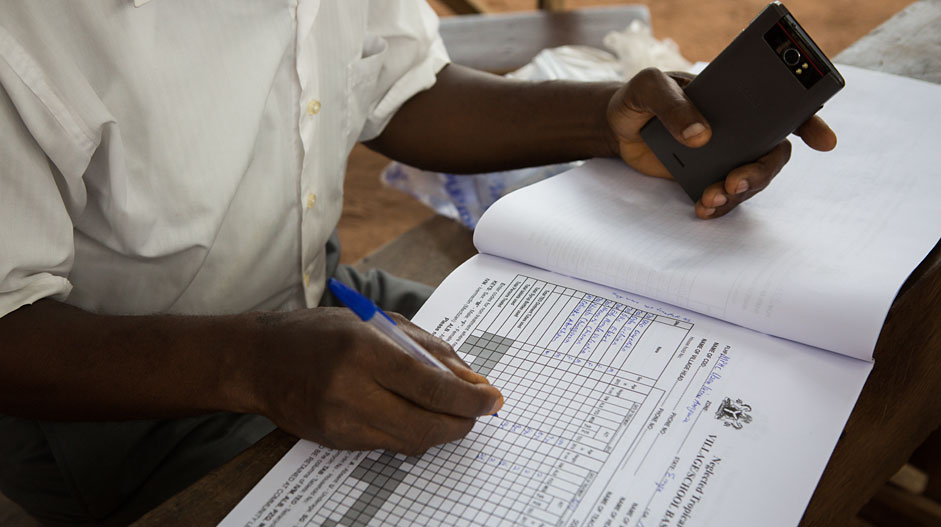 Nnamchi, a volunteer drug distributor for the Ministry of Health, keeps detailed treatment records for all the children under his care.