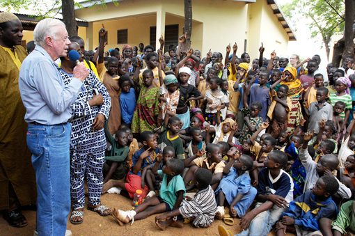 Former U.S. President Jimmy Carter addresses Ghanaian children outside Savelugu Hospital, asking 