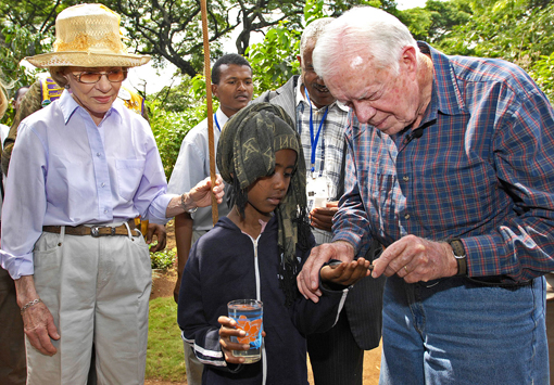 President and Mrs. Carter help measure people's heights to determine how many Mectizan® treatments should be received to prevent the parasitic disease river blindness.