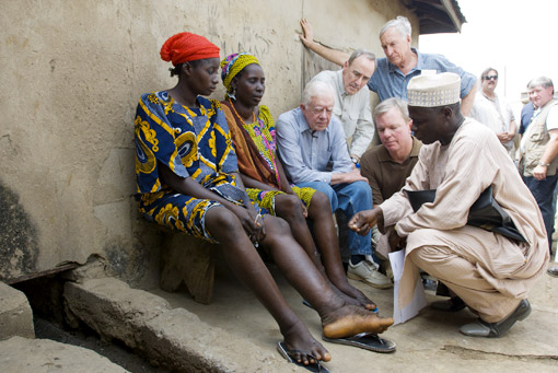 President Carter learns about the suffering of two patients with swollen legs and feet, symptomatic of lymphatic filariasis infection.