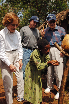 Former U.S. President Jimmy Carter, Carter Center Board of Trustees Chair John Moores, and former First Lady Rosalynn Carter observe a young Ethiopian girl while she washes her face to prevent the bacterial eye disease trachoma.