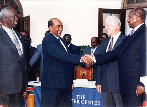 Sudan President Omar Al-Bashir (left) shakes the hand of Uganda President Yoweri Museveni as Kenya President Daniel arap Moi and President Carter look on.