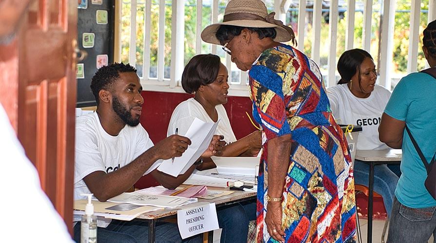  In Georgetown, the capital of Guyana, a woman checks in at her polling station for the March 2, 2020, elections.