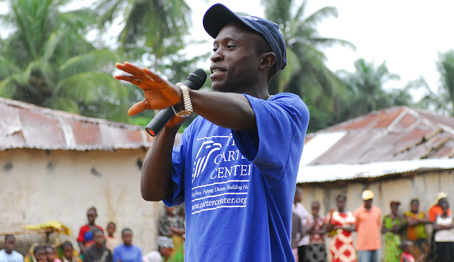 Emmanuel Kwenah, leader of the Bong Youth Association, greets villagers in rural Leleh, located near Gbarnga in 2006. Over the years, The Carter Center has partnered with community-based organizations to provide education programs on the rule of law and freedom of information.