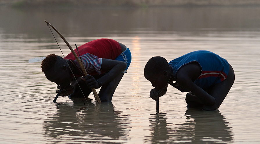 Boys drink water from pipe filters