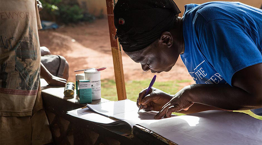 A village volunteer in southern Nigeria distributes medications.