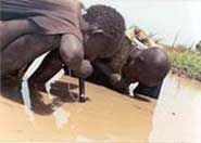 Young boys using pipe filters in Southern Sudan.