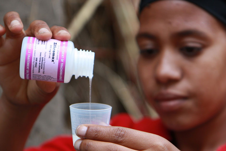 A local community health worker in Ethiopia pours a dose of Zithromax. 