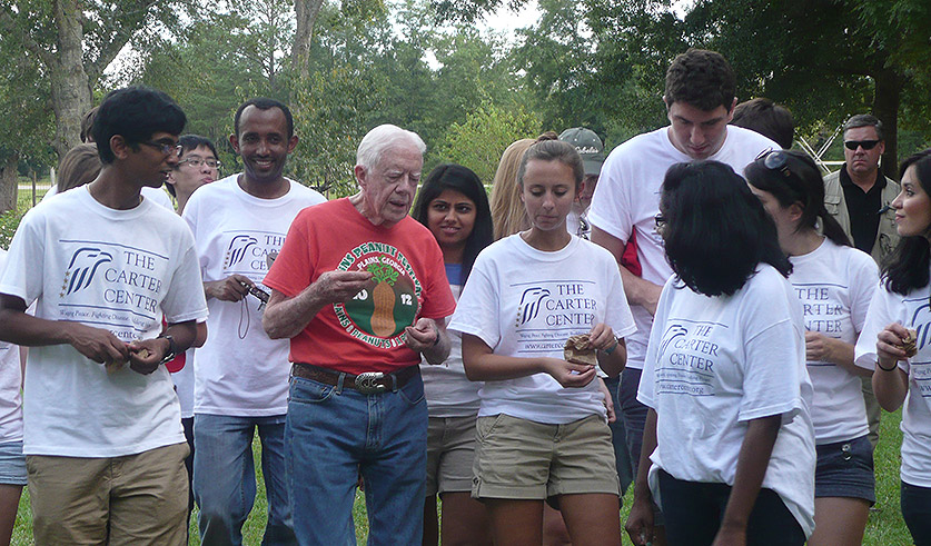 Photo of President Carter and a group of interns at his boyhood farm in Plains, Ga.