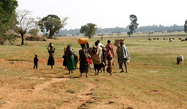 Team of health workers plus local community members head toward a village to provide treatment.
