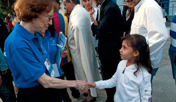 Mrs. Carter greets a little girl who has come to watch her parents vote in Sidi Bou Said.