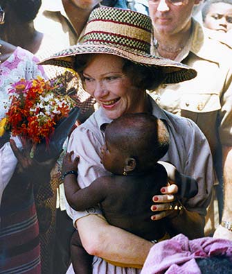 Mrs. Carter holds a baby in Nigeria.